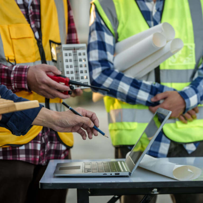 engineers discussing a solar energy project with a small solar panel model on the table, a laptop