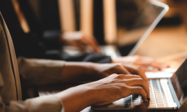 Business professionals working on laptops, representing expert ERP implementation and digital transformation.