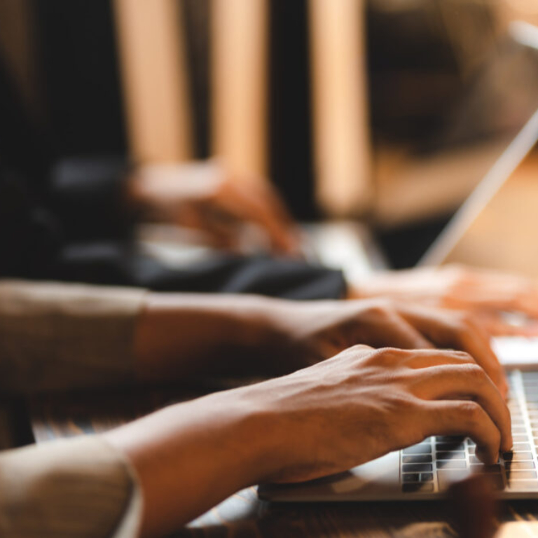 Business professionals working on laptops, representing expert ERP implementation and digital transformation.