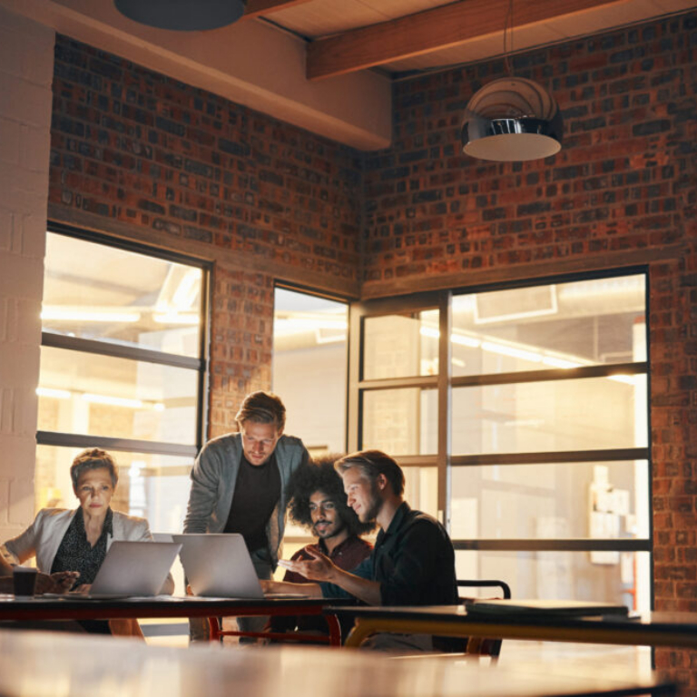 Business team collaborating on laptops during an ERP software implementation project using NetSuite and Sage software solutions.