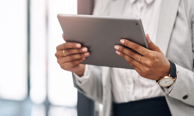 Businesswoman in professional attire reviewing data on a tablet